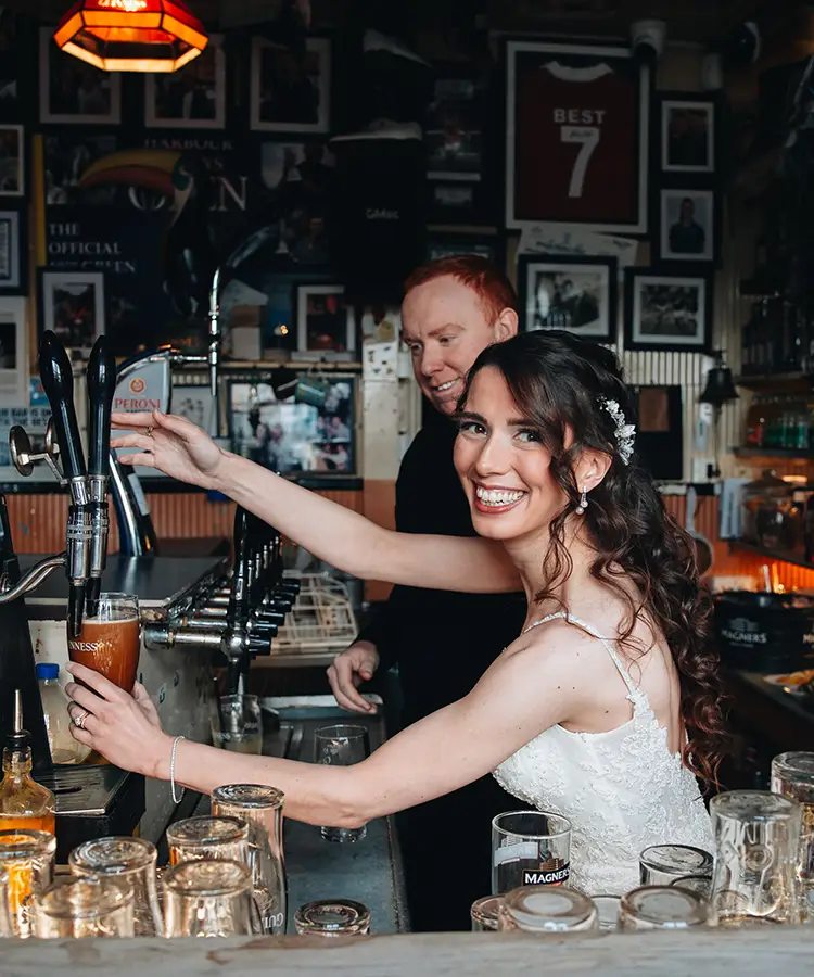 Elopement Wedding Bride pulling a Guinness in the Harbour Bar in Portrush